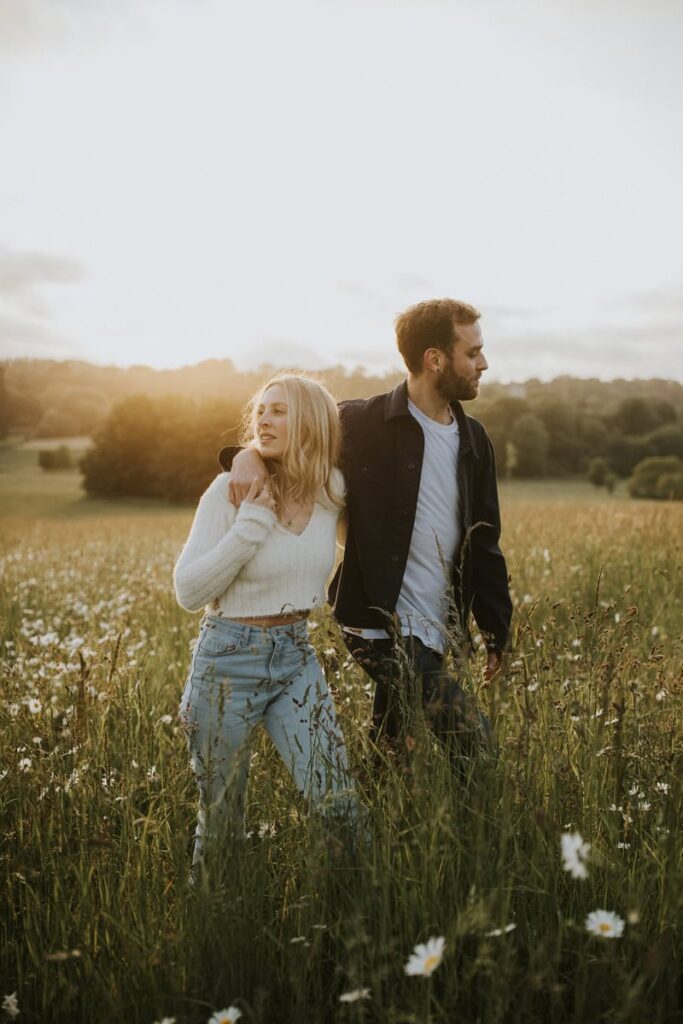 Kent Wedding Photographer, engaged couple walk together arms around each other in the grass