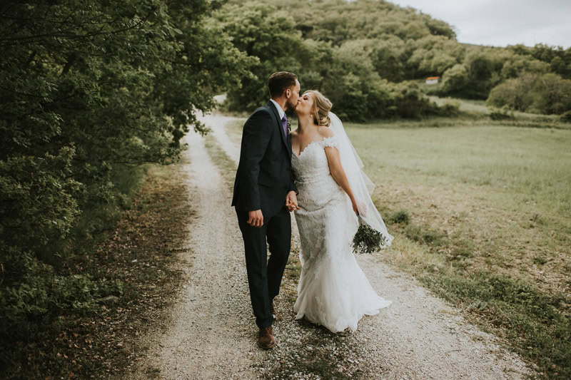 Wedding Photographer, a bride and groom kiss on a countryside path