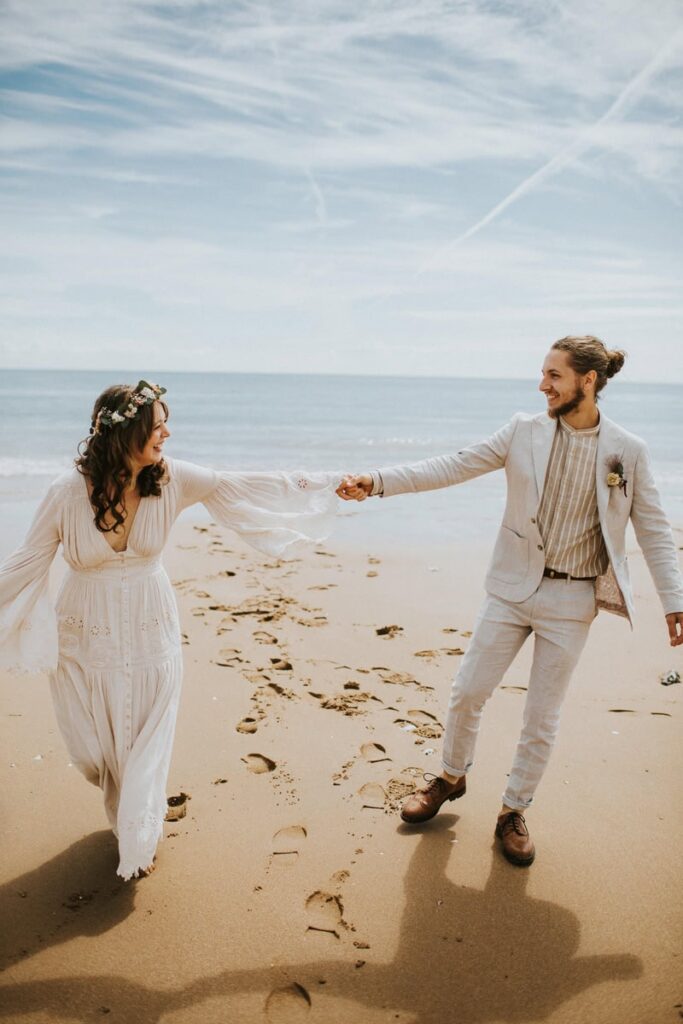 Kent Wedding Photographer, newly weds hold hands and gaze at each other before the ocean